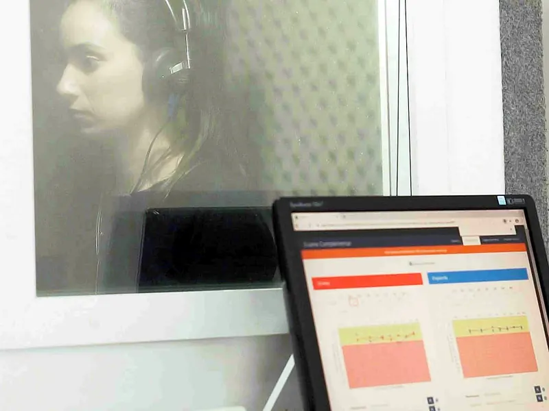 Exame de audiometria: a paciente na cabine acústica e o resultado na tela